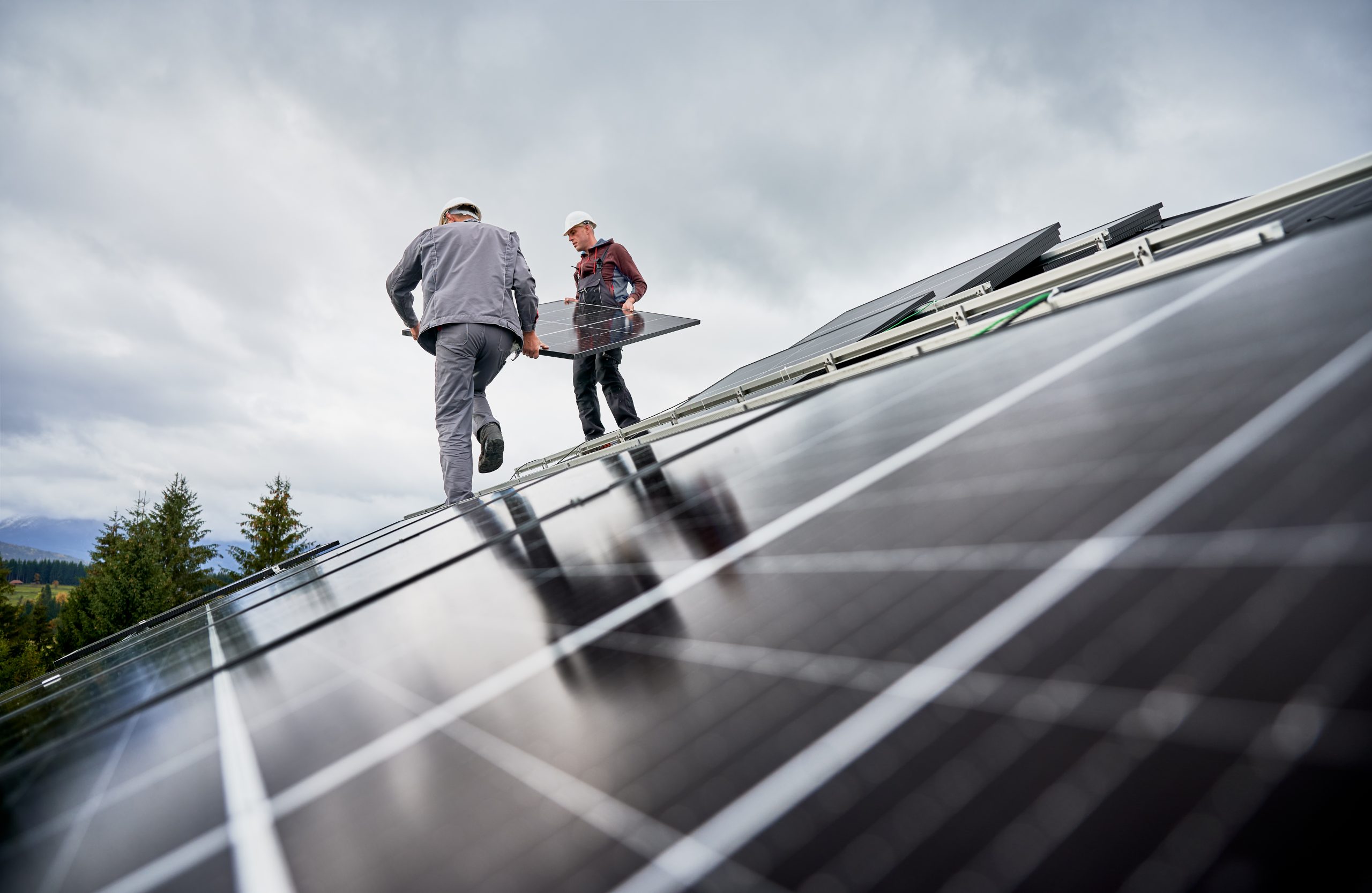 Fachkräfte montieren Photovoltaikmodule auf einem Hausdach – professionelle Installation von Solartechnik durch Haustechnik-Dienstleister